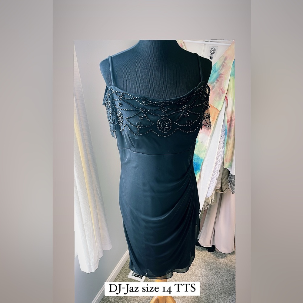 Semi formal black dress with beading has sheer sleeves with beading and strap